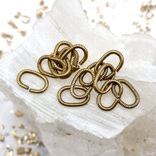 Load image into Gallery viewer, Antique Gold 9mm Textured Oval Jump Rings - 12pcs
